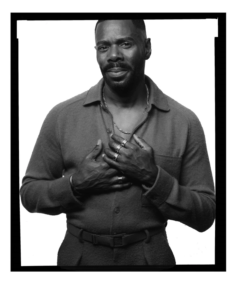 Actor Colman Domingo in B&W, hands layered over his chest, silver rings and chain, open-collar shirt, steady gaze by Austin.