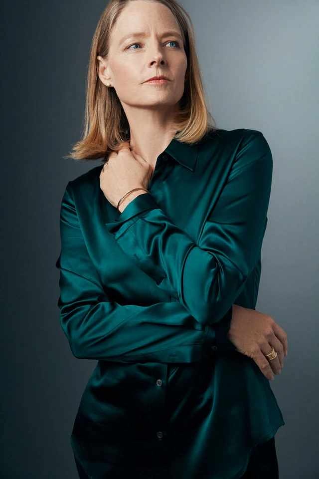 Actress Jodie Foster, two-time Oscar winner, in a teal satin shirt, arms crossed, gaze lifted against grey by Austin Hargrave