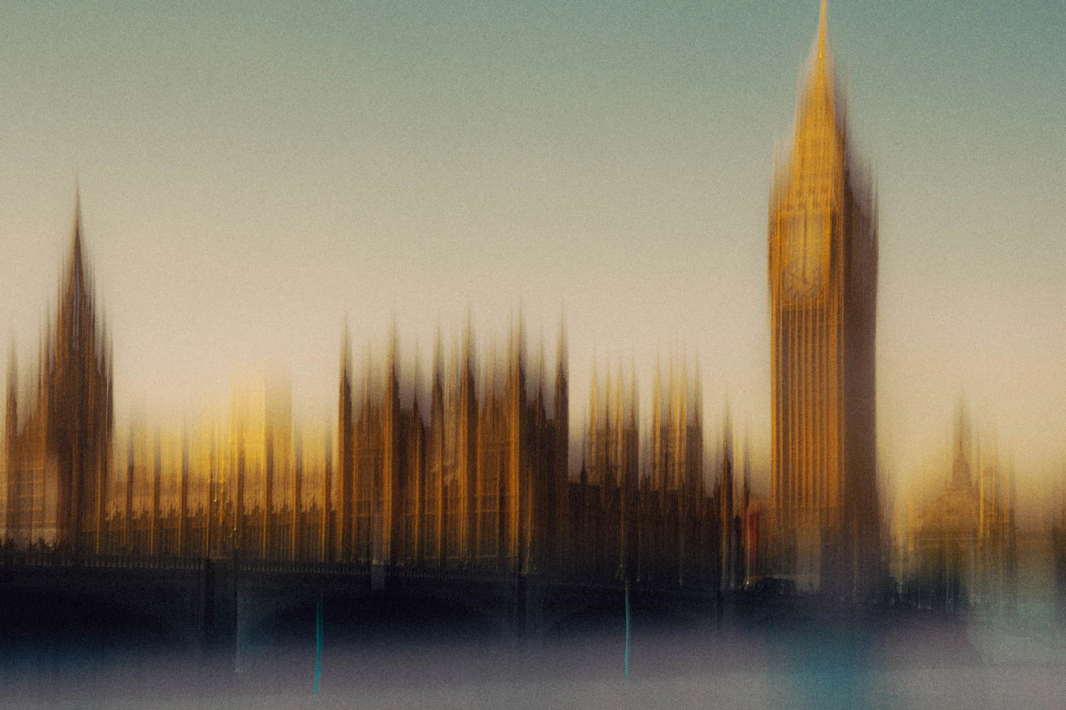 Big Ben and the Houses of Parliament dissolve into golden motion blur at dusk, warm amber light glowing across the Thames.